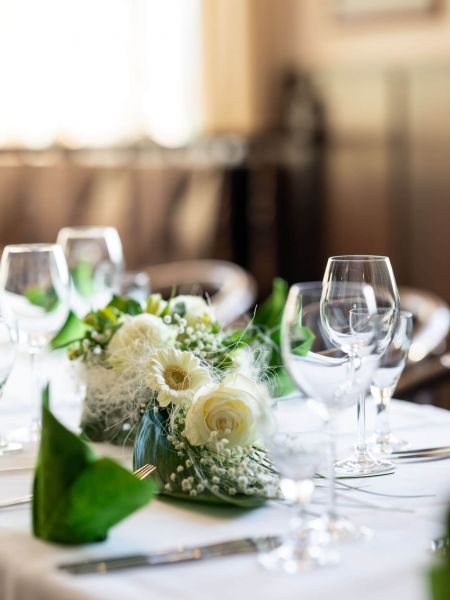 Gedeckter Tisch mit weißen Blumen, Wein- und Wassergläsern im Restaurant Lübsche Thorweide Wismar